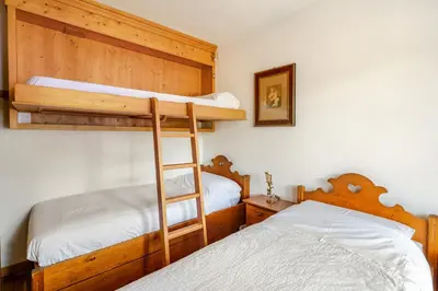 two beds in a room with two bunk beds at Dolce Casa Cortina Centro-Ski in Cortina dʼAmpezzo
