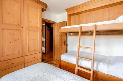 a bedroom with two bunk beds and a ladder at Dolce Casa Cortina Centro-Ski in Cortina dʼAmpezzo