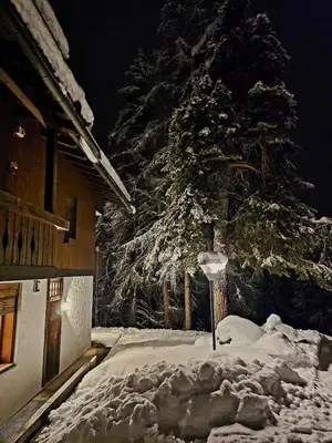 a pile of snow next to a house with a christmas tree at APARTMENT - Ski in&out-accesso diretto alle piste in Cortina dʼAmpezzo
