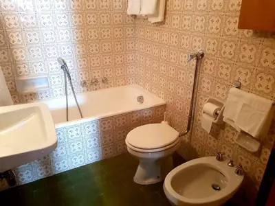 a bathroom with a toilet and a tub and a sink at APARTMENT - Ski in&out-accesso diretto alle piste in Cortina dʼAmpezzo