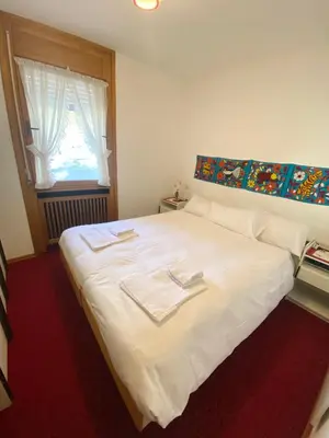a bedroom with a white bed with two towels on it at APARTMENT - Ski in&out-accesso diretto alle piste in Cortina dʼAmpezzo