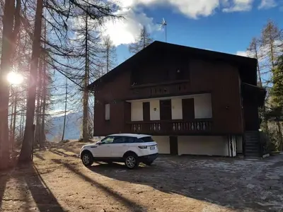 a white car parked in front of a house at APARTMENT - Ski in&out-accesso diretto alle piste in Cortina dʼAmpezzo