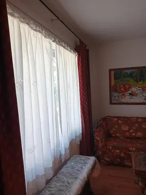 a living room with white curtains and a couch at Ca' Ravagnan in Cortina dʼAmpezzo
