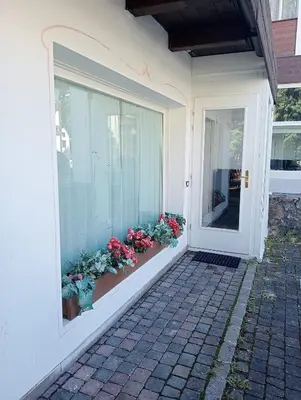 a front door of a house with flowers in a window at Ca' Ravagnan in Cortina dʼAmpezzo