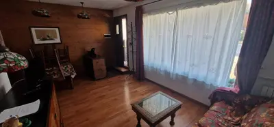 a living room with a couch and a large window at Ca' Ravagnan in Cortina dʼAmpezzo