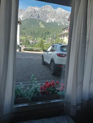a window view of a car parked in a parking lot at Ca' Ravagnan in Cortina dʼAmpezzo