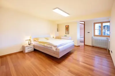 a large bedroom with a bed and a wooden floor at Apartment Seenah in Caldaro