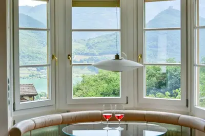 a dining room with two wine glasses and windows at Apartment Seenah in Caldaro