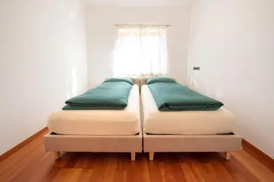 two twin beds in a room with a window at Apartment Seenah in Caldaro