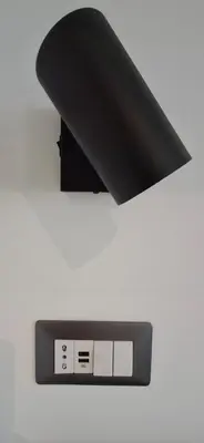 a black alarm clock on a white wall at Manzoni 99 in Merano
