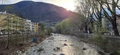 a river in a city with a mountain in the background at Manzoni 99 in Merano