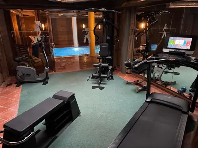 a gym with several exercise equipment and a woman on a treadmill at Sport Hotel Astoria Residence in La Villa
