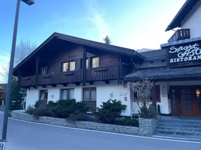 a building with a sign for a restaurant at Sport Hotel Astoria Residence in La Villa