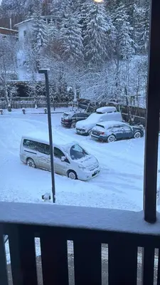a group of cars parked in a parking lot covered in snow at Sport Hotel Astoria Residence in La Villa
