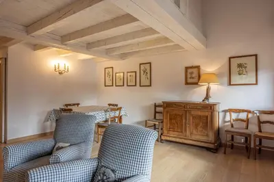a living room with blue chairs and a table at Casa Funivia, immersa nel verde e vicina al centro di Cortina in Cortina dʼAmpezzo
