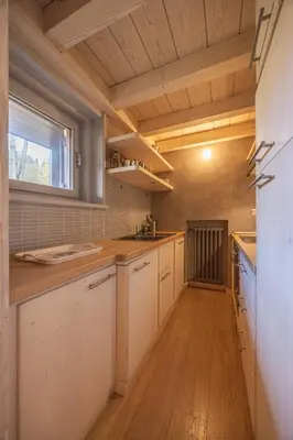 a kitchen with white cabinets and a window at Casa Funivia, immersa nel verde e vicina al centro di Cortina in Cortina dʼAmpezzo
