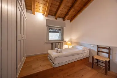 a small bedroom with a bed and a window at Casa Funivia, immersa nel verde e vicina al centro di Cortina in Cortina dʼAmpezzo