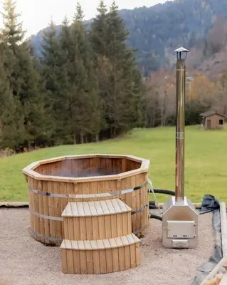 a wooden tub sitting on top of a field at Chalet Al Maso Val Calamento in Telve