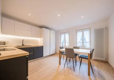 a kitchen with a table and chairs in a room at Appartamento Dolomiti Dream 1 in Falcade