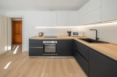 a kitchen with black cabinets and a counter top at Appartamento Dolomiti Dream 1 in Falcade