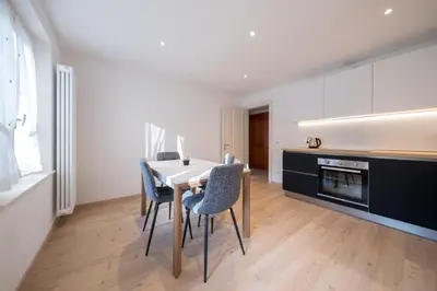 a kitchen with a table and chairs in a room at Appartamento Dolomiti Dream 1 in Falcade