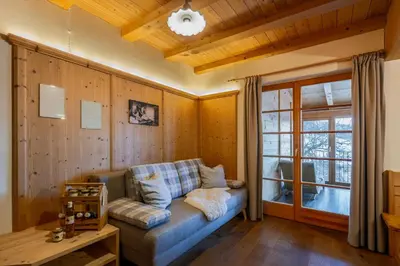 a living room with a couch and a window at Froetscherhof, Urlaub auf dem Bio-Bauernhof in Brixen, Appartments, Sauna und BrixenCard in Bressanone