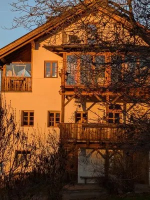 a large house with a wooden balcony in front of it at Froetscherhof, Urlaub auf dem Bio-Bauernhof in Brixen, Appartments, Sauna und BrixenCard in Bressanone