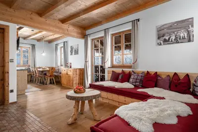 a living room with a red couch and a table at Froetscherhof, Urlaub auf dem Bio-Bauernhof in Brixen, Appartments, Sauna und BrixenCard in Bressanone