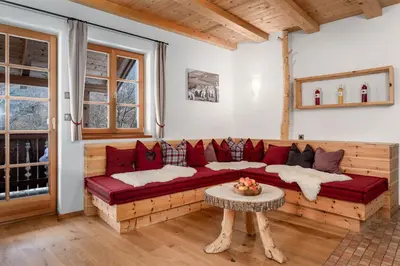 a living room with a red couch and a table at Froetscherhof, Urlaub auf dem Bio-Bauernhof in Brixen, Appartments, Sauna und BrixenCard in Bressanone