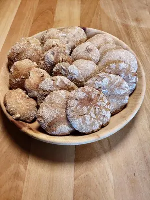 a bowl of powdered donuts on a wooden table at Froetscherhof, Urlaub auf dem Bio-Bauernhof in Brixen, Appartments, Sauna und BrixenCard in Bressanone