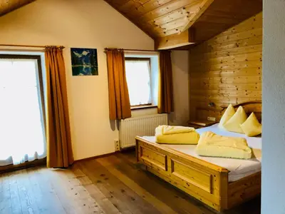 a bedroom with a bed with yellow pillows on it at Speckstube Eggerhof in Braies