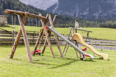 a playground with a slide in a field at Speckstube Eggerhof in Braies