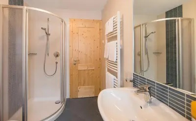 a bathroom with a tub and a sink and a shower at Speckstube Eggerhof in Braies