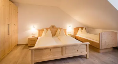 a bedroom with two beds in a attic at Speckstube Eggerhof in Braies
