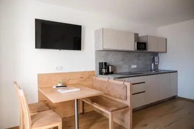 a small kitchen with a wooden table and a microwave at Fritzenhof in Termeno