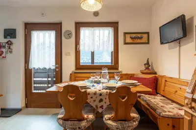 a living room with a table and a couch at Trilo Ciasa de l'Ora in Cavalese