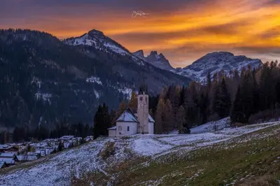 an old church on a hill in the mountains at Appartamento Dolomiti Dream 2 in Falcade