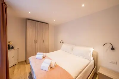 a bedroom with a white bed with towels on it at Appartamento Dolomiti Dream 2 in Falcade
