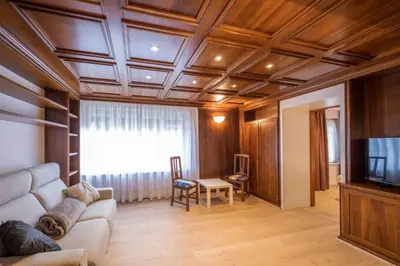 a living room with a couch and a tv at Appartamento Dolomiti Dream 2 in Falcade
