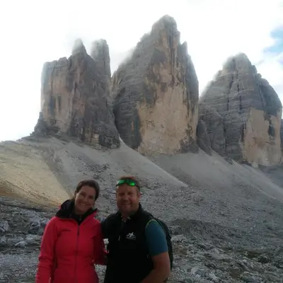 a man and a woman standing in front of some rocks at Hof Zerund in Castelrotto