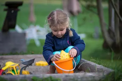 a little girl playing with a toy in a sandbox at Hof Zerund in Castelrotto
