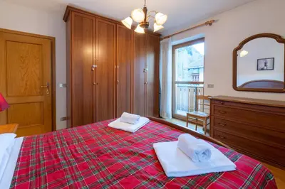 a bedroom with a red bed with towels on it at 7 min dal centro, top per sciare e park in Piaia