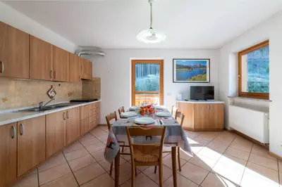 a kitchen with a table and chairs in a room at 7 min dal centro, top per sciare e park in Piaia