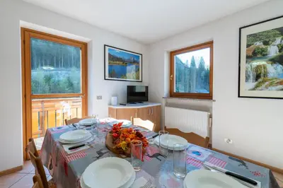 a dining room with a table with plates and glasses at 7 min dal centro, top per sciare e park in Piaia
