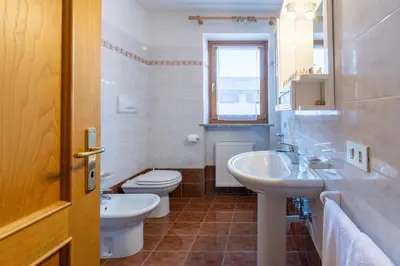 a white bathroom with a sink and a toilet at 7 min dal centro, top per sciare e park in Piaia