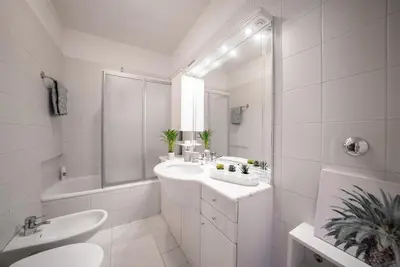 a white bathroom with a sink and a tub at Apartment Schoenblick in Caldaro