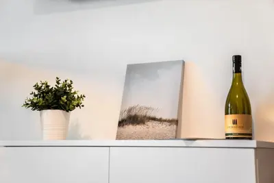 a bottle of wine and a book on a shelf at Apartment Schoenblick in Caldaro