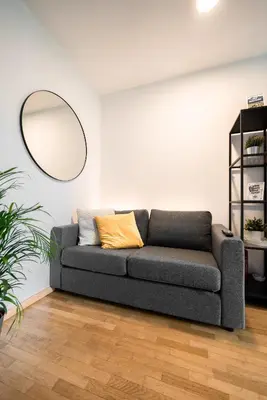 a couch in a living room with a mirror at Apartment Schoenblick in Caldaro