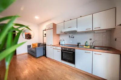 a kitchen with white cabinets and a refrigerator at Apartment Schoenblick in Caldaro