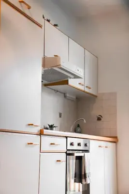 a kitchen with white cabinets and a stove at Apartment Schoenblick in Caldaro